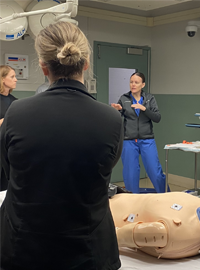 Commander Mary Decoteau, MD, leads the Navy team in discussion as they debrief after a patient simulation.